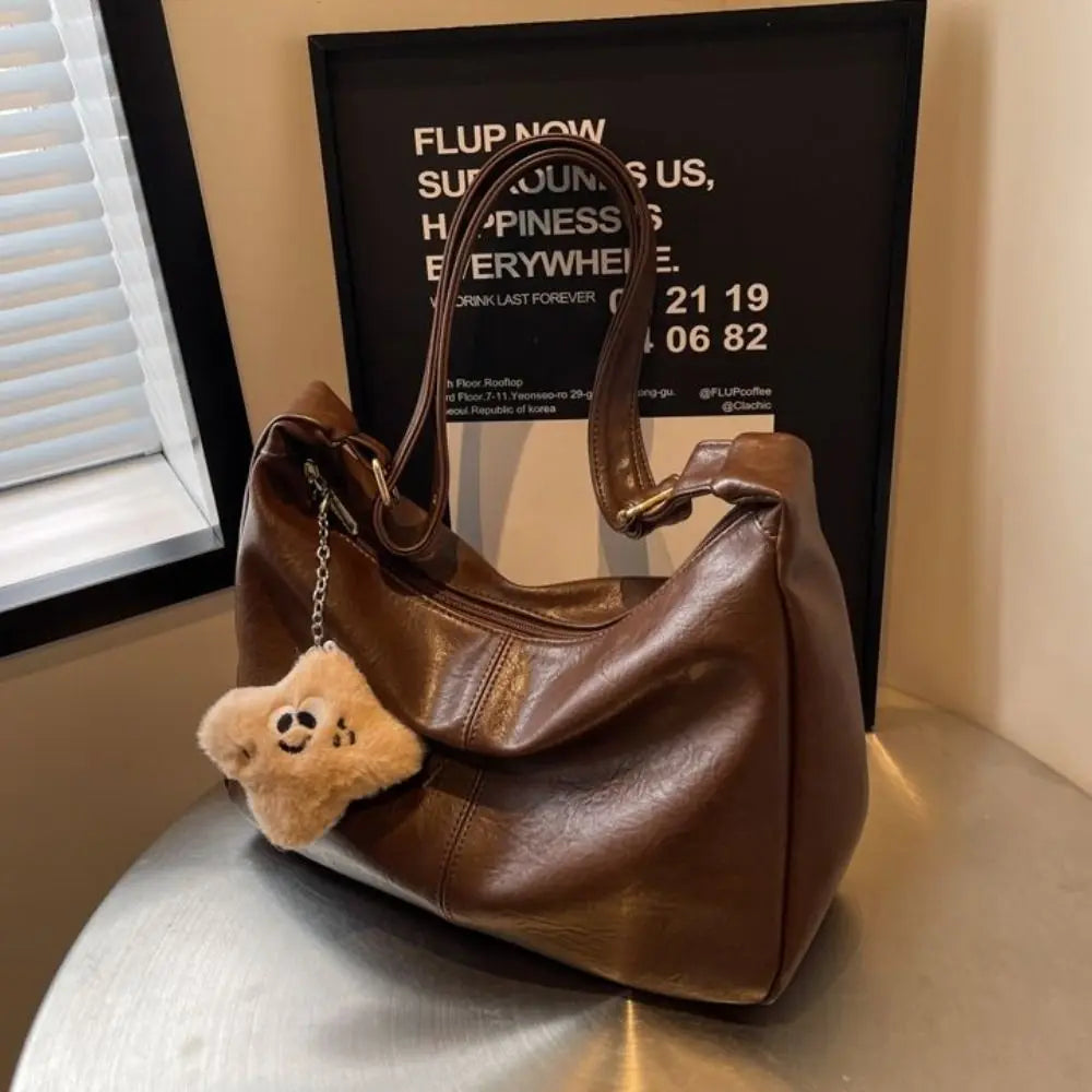 Slouchy shoulder bag brown PU leather with top handles and beige plush charm