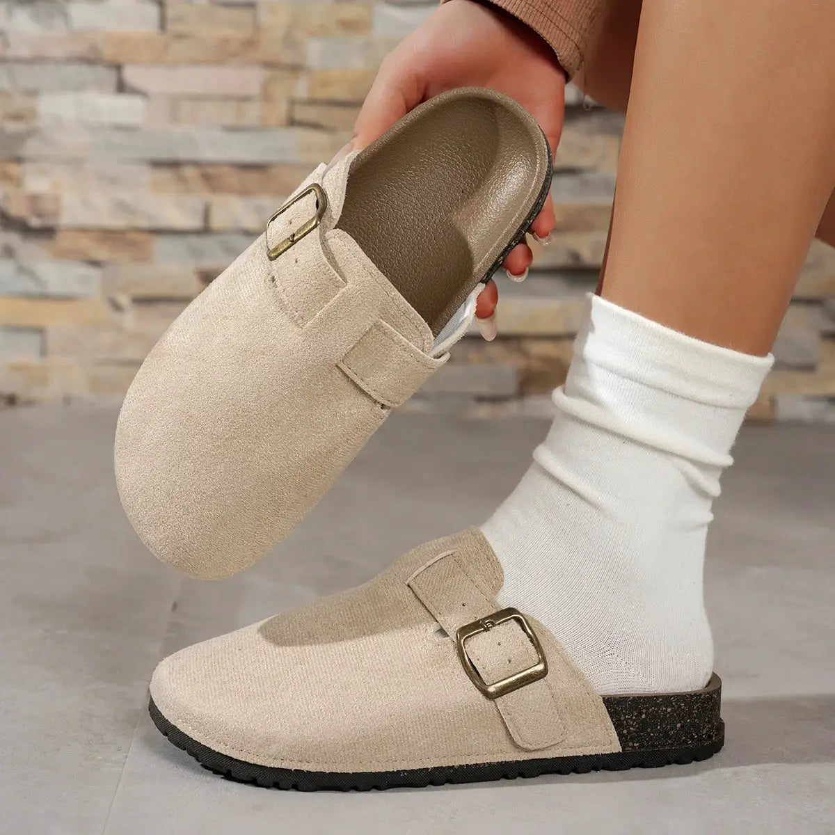 Beige suede buckle-strap women's loafers; flat sole, casual slip-on style.