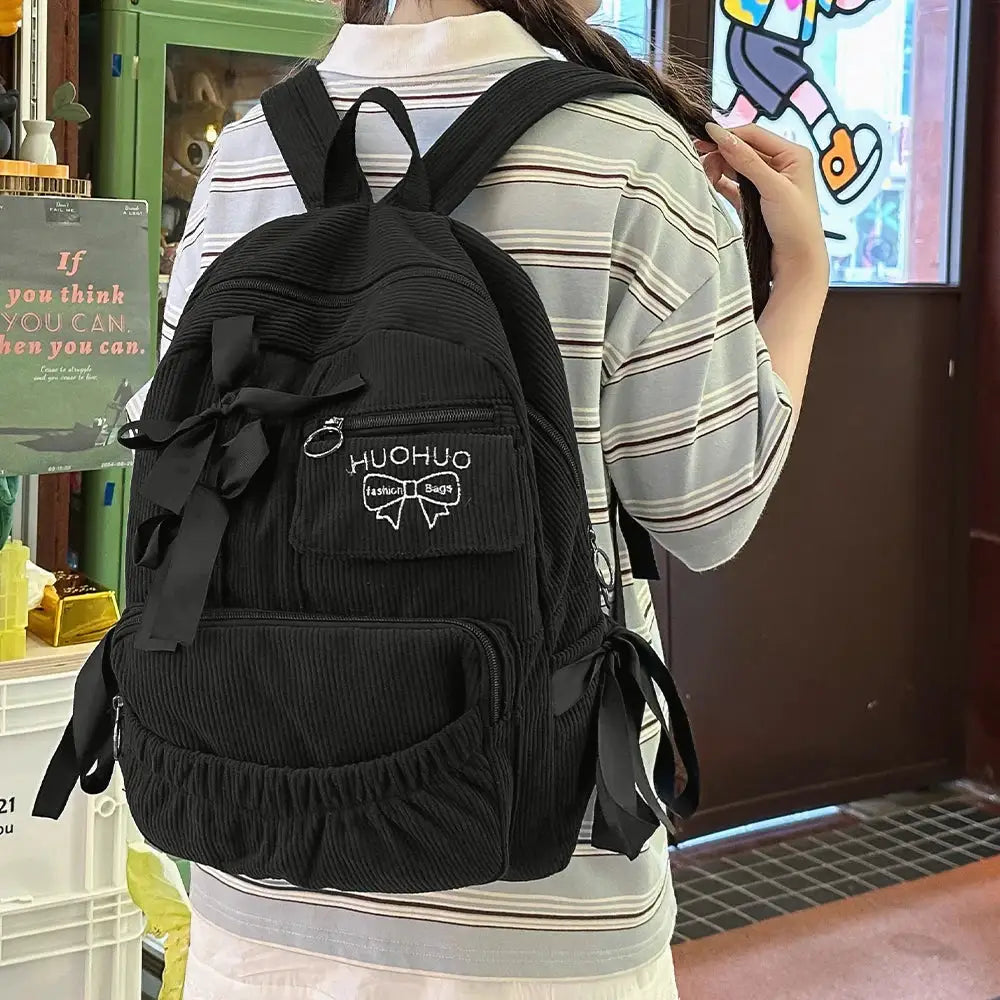 Simples Market black corduroy backpack with bow accents and HUOHUO patch, front pocket for students