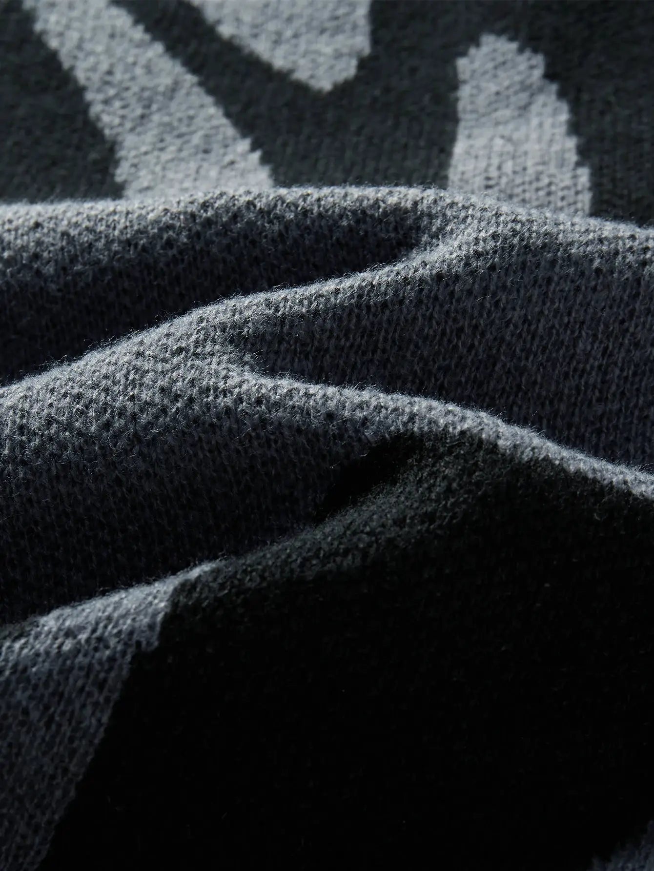 Men's pullover sweater fabric in dark charcoal knit with irregular jacquard pattern