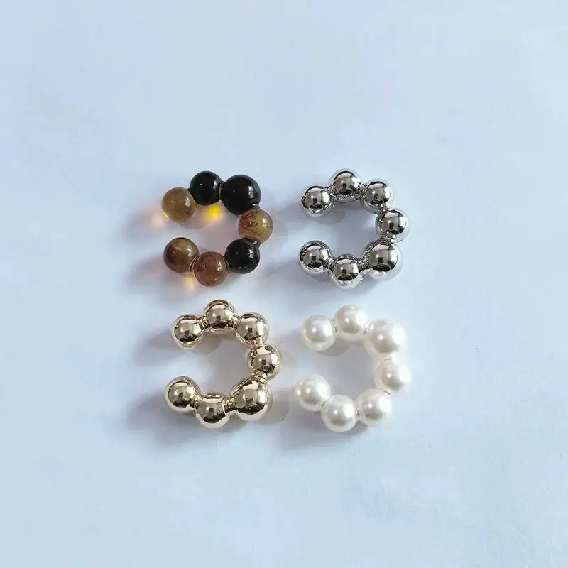 4-piece C-shaped ear clip set with acrylic beads and faux pearls in black, amber, silver, and white
