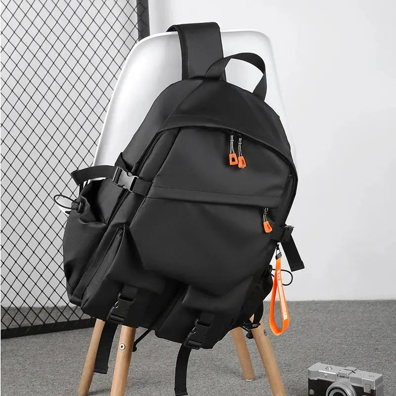 Backpack by Simples Market, black waterproof laptop bag with 15.6-inch compartment and multiple pockets.