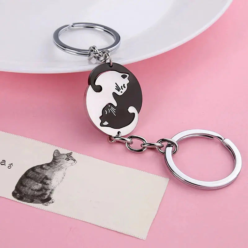 Stainless steel cat hug keychain featuring a round black-and-white yin-yang cat pendant