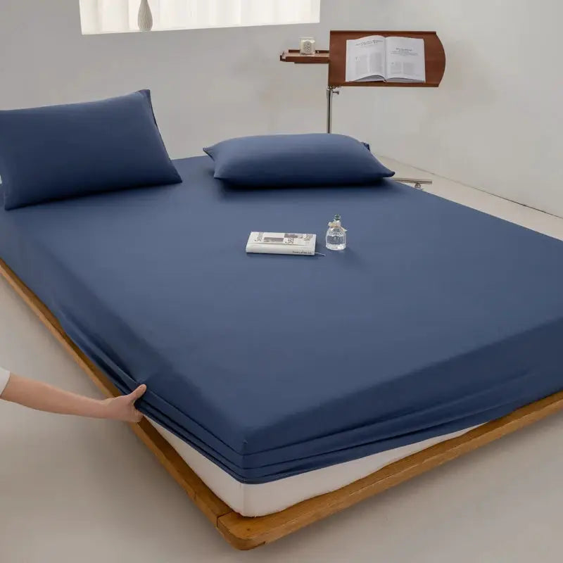 Soft cotton fitted sheet in blue with elastic edge for a mattress on a wooden bed frame