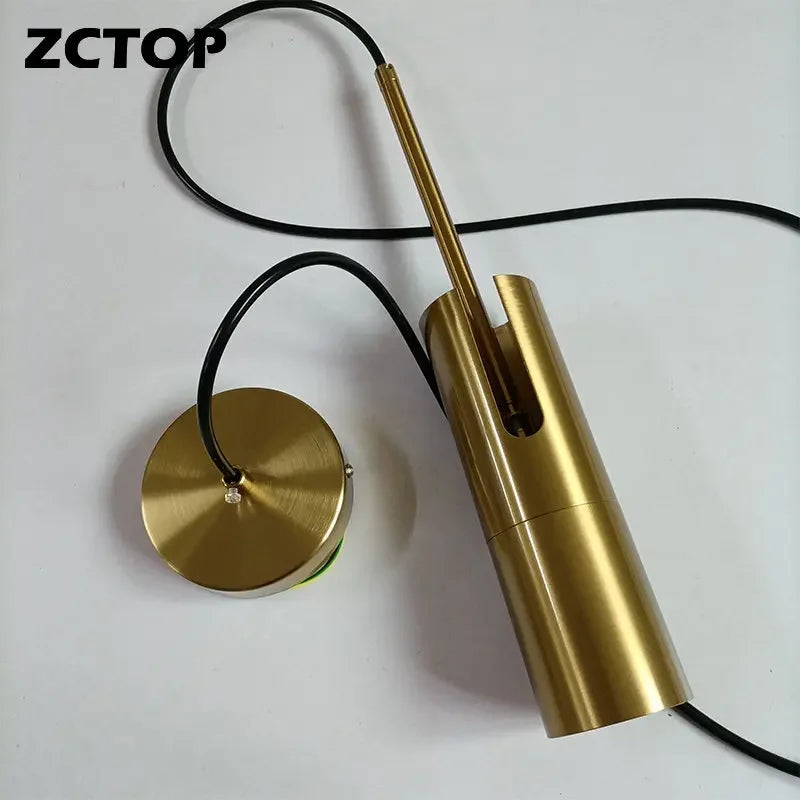 Minimalist LED hanging pendant light in brass gold with black cord and ceiling canopy
