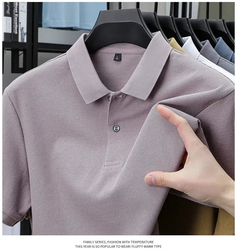 Men's lavender 100% cotton polo shirt on a hanger; textured knit fabric with several other colors visible in the background.