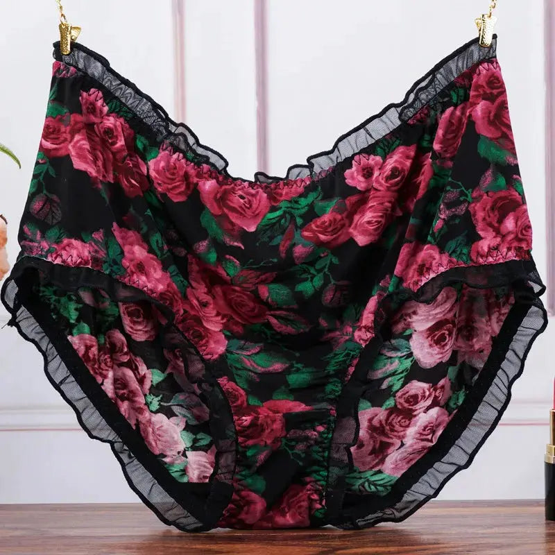 Womens floral print mid-rise panties with pink roses on black, lace trim and ruffled edges.