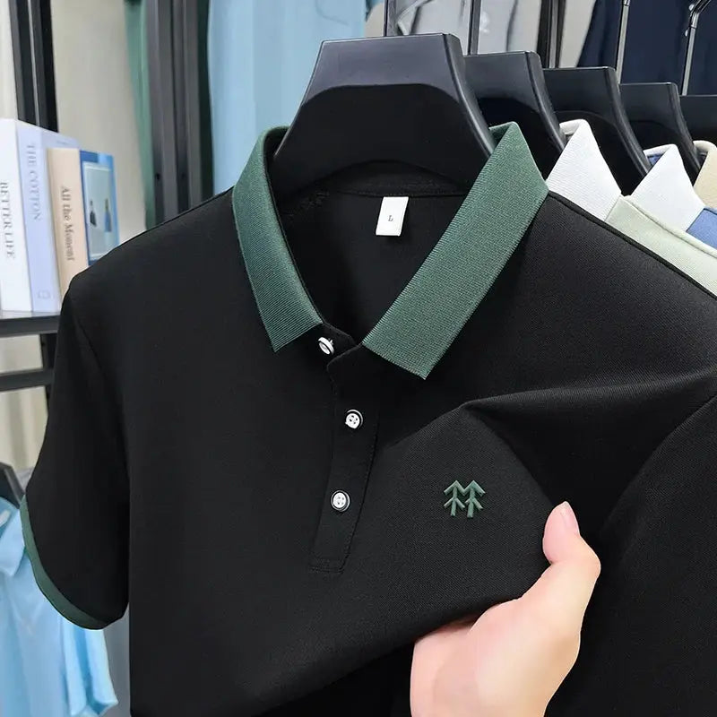 Polo shirt by Simples Market, black silk-cotton with green collar and cuffs, embroidered chest logo.