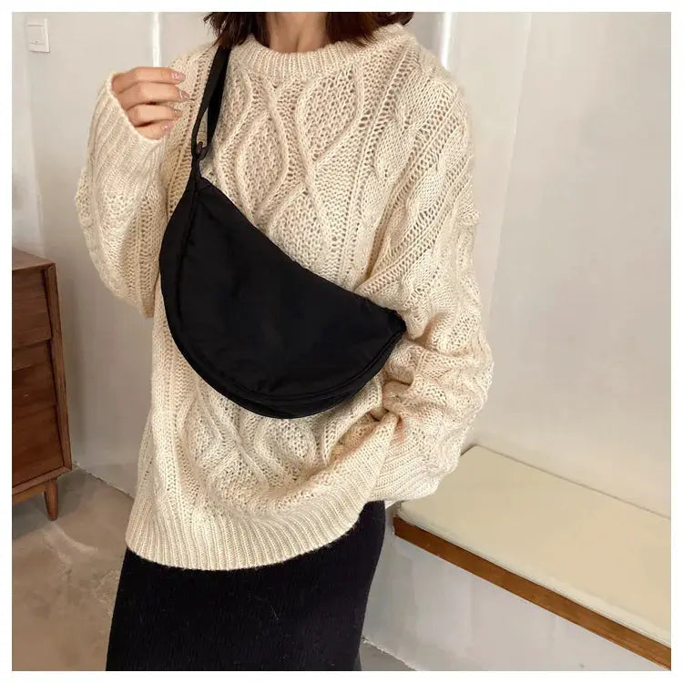 Casual nylon hobo crossbody bag, black, large-capacity; worn by a woman in a cream chunky knit sweater