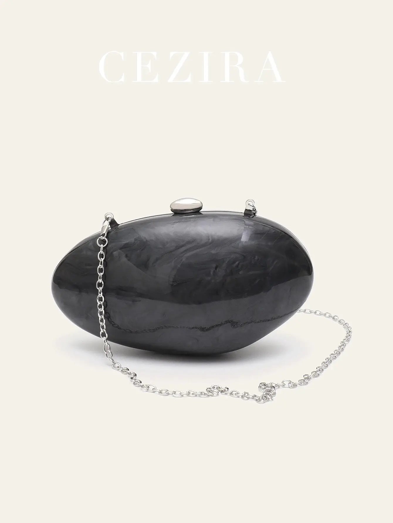Shell-shaped black acrylic clutch bag with silver chain strap by Simples Market