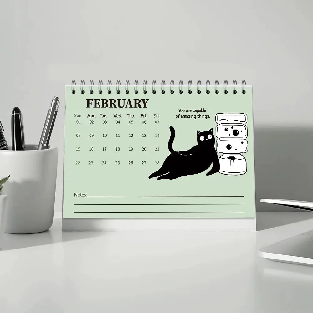Cat-themed desktop calendar, mint green February page with a black cat illustration, 12-month planner