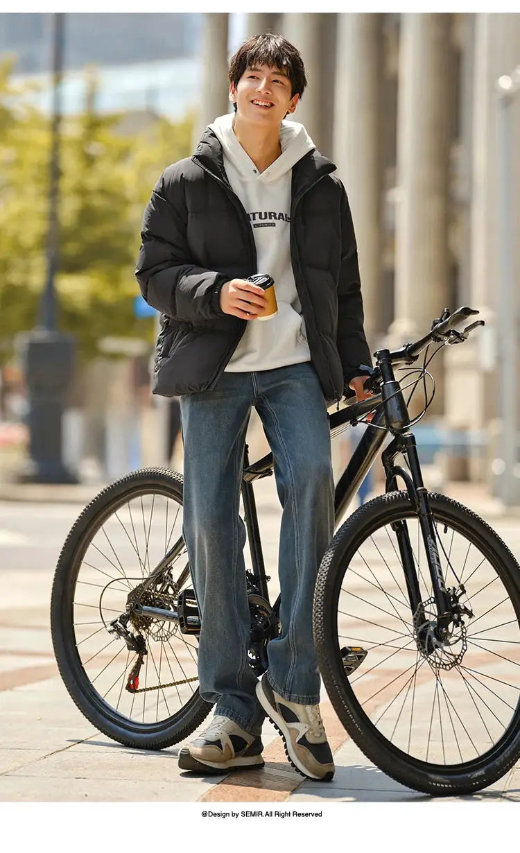 Semir black down puffer jacket, windproof and waterproof outerwear worn over a white hoodie beside a bike