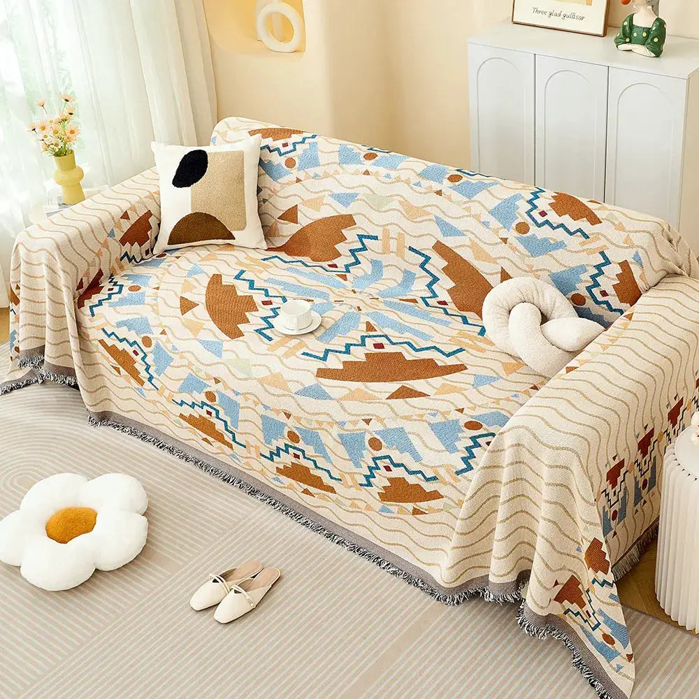 Sofa throw blanket in cream with blue and brown geometric pattern, full-coverage sofa cover on beige sofa