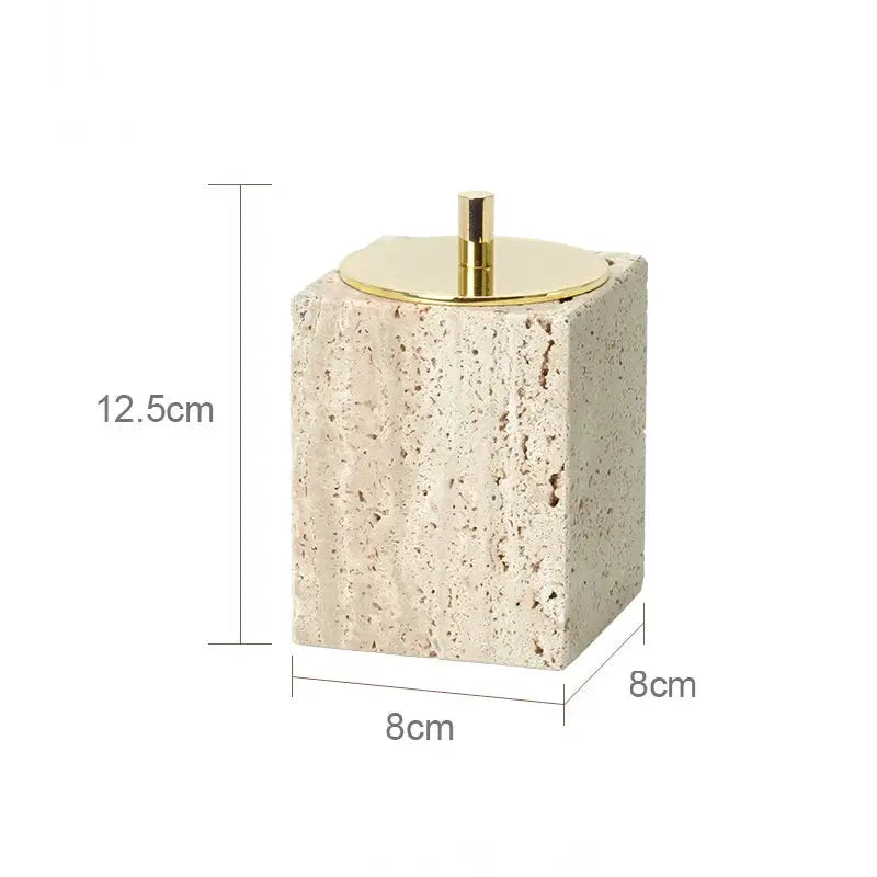 Beige travertine soap dispenser on a square block with a gold pump