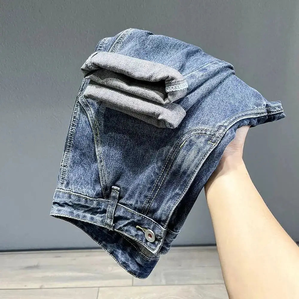Men's blue denim jeans with rolled cuffs and loose tapered fit, visible stitching