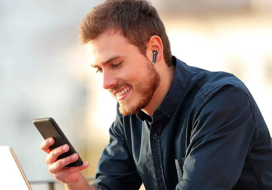Tronsmart Bluetooth earphones worn by a smiling man using a smartphone, black wireless earbuds for running