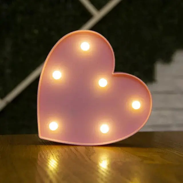 Pink heart-shaped LED lamp by Simples Market with warm white bulbs, decorative night light.