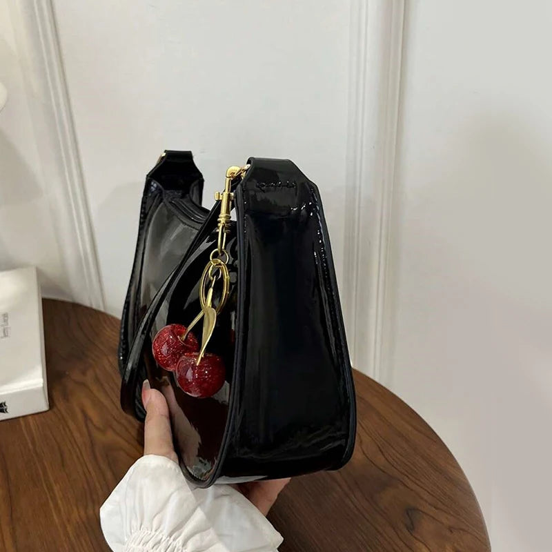 Women's black patent PU leather shoulder bag with gold hardware and cherry pendant charm