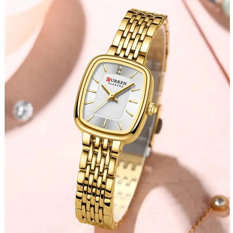 CURRN 9093 women's gold-tone quartz watch with diamond accents and white dial on a link bracelet