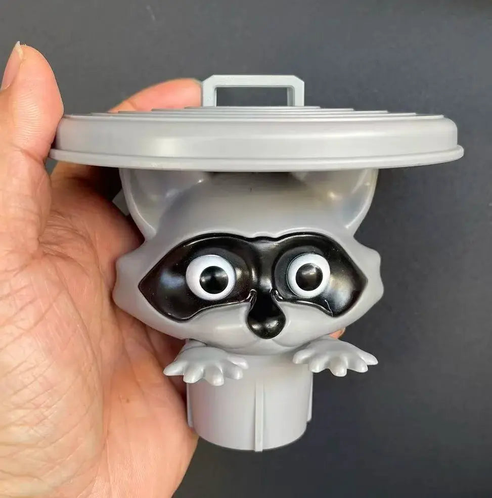 Raccoon-themed toilet paper holder in gray plastic with googly eyes, a cute bathroom decor accessory