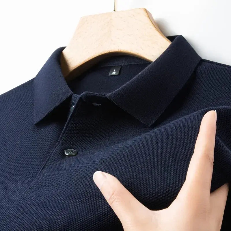 Men's navy polo shirt on hanger with polo collar, button placket and textured knit fabric