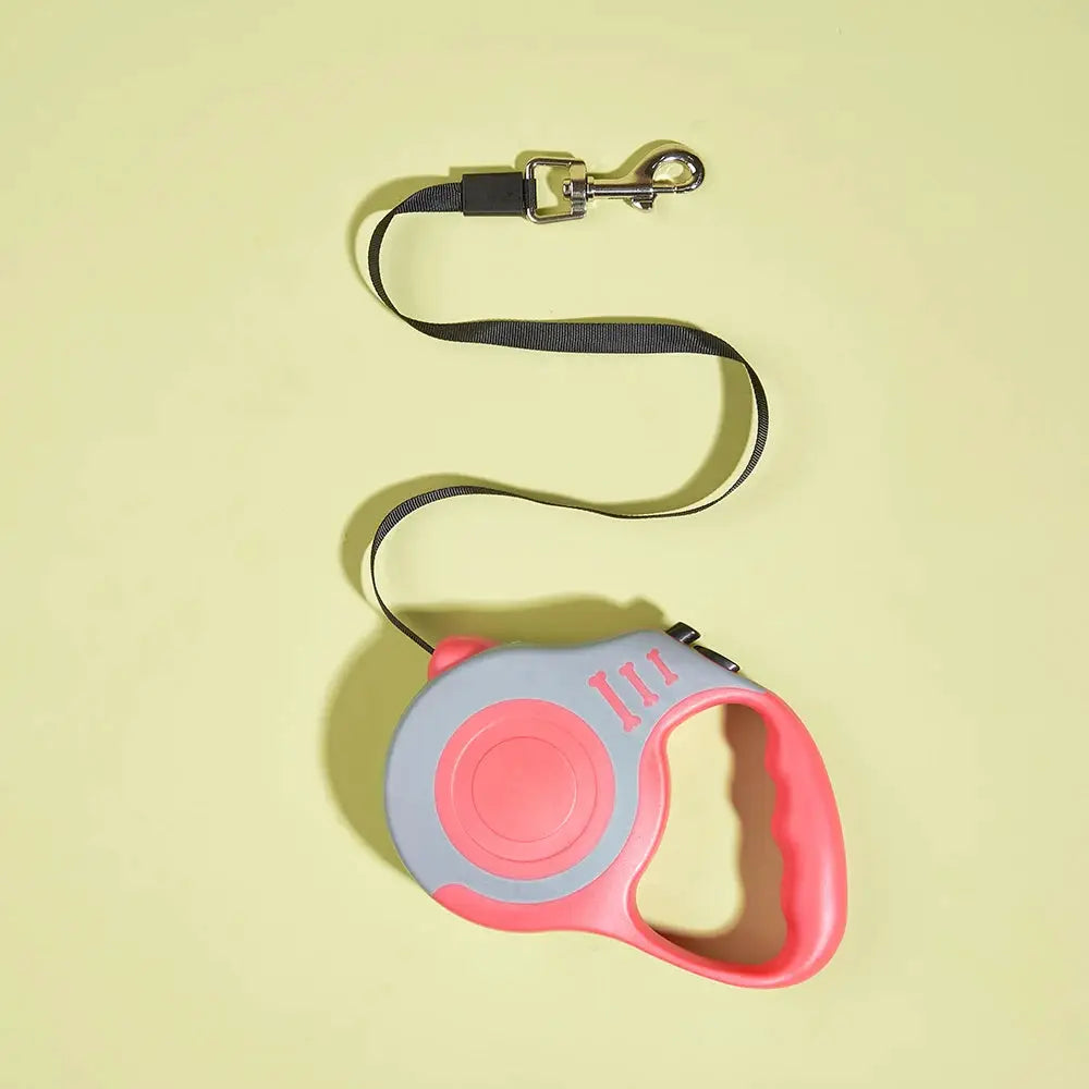 Retractable dog leash with pink handle and gray housing, nylon cord, metal clip