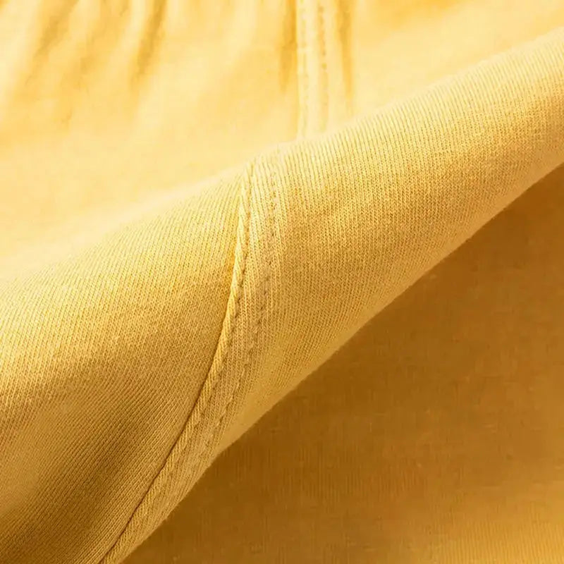 Men's yellow underwear boxers fabric close-up showing seam stitching