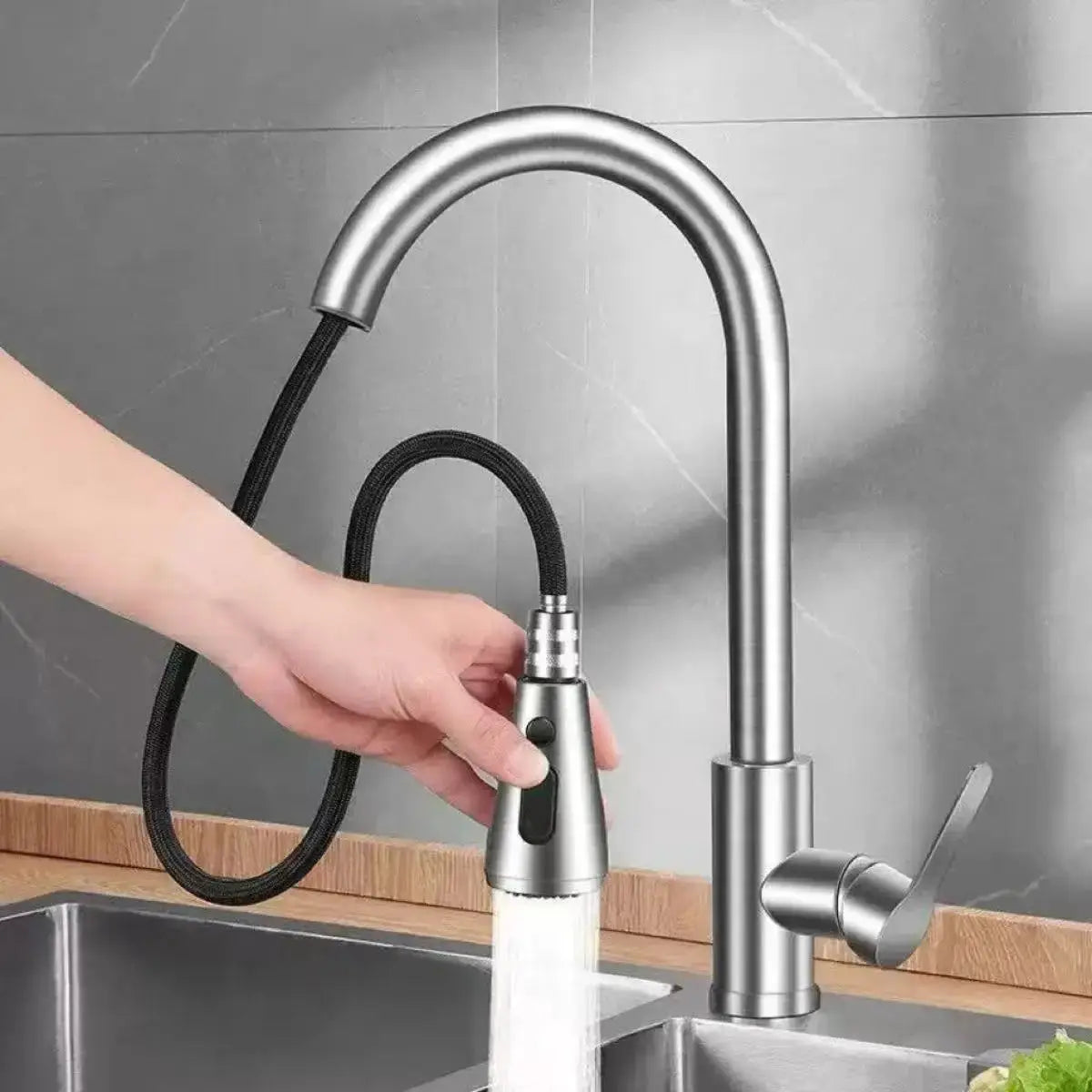 Stainless steel kitchen faucet with high-arc pull-out spray head on a black hose for single-hole sink installation.