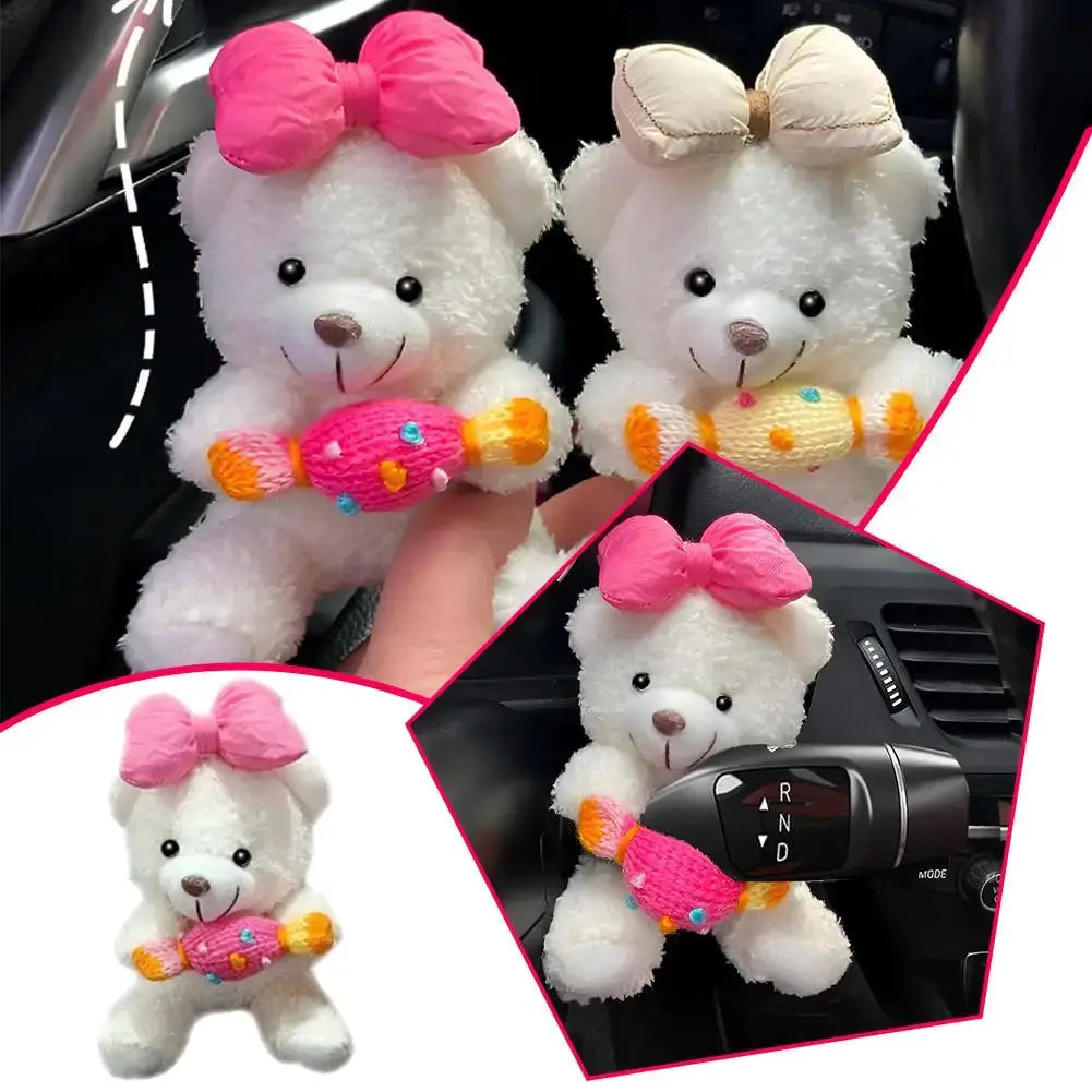 Two Pilot Bear car gear shift ornaments by Simples Market; white teddies with pink bows, each holding bone charms
