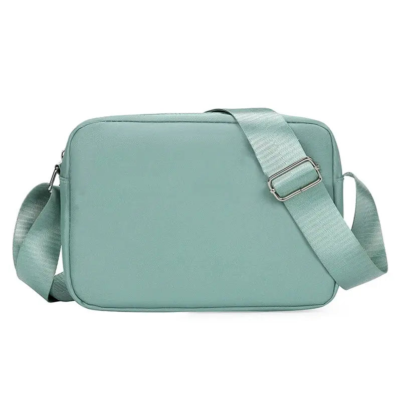 Seafoam green crossbody bag with adjustable shoulder strap and minimalist design