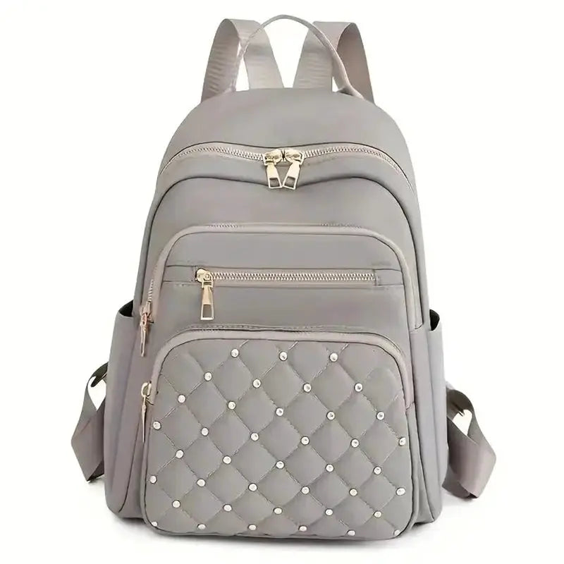Travel backpack by Simples Market, gray quilted bag with gold zippers and multiple pockets