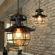 Industrial black metal pendant lights with cage shades, two hanging lamps with Edison bulbs.