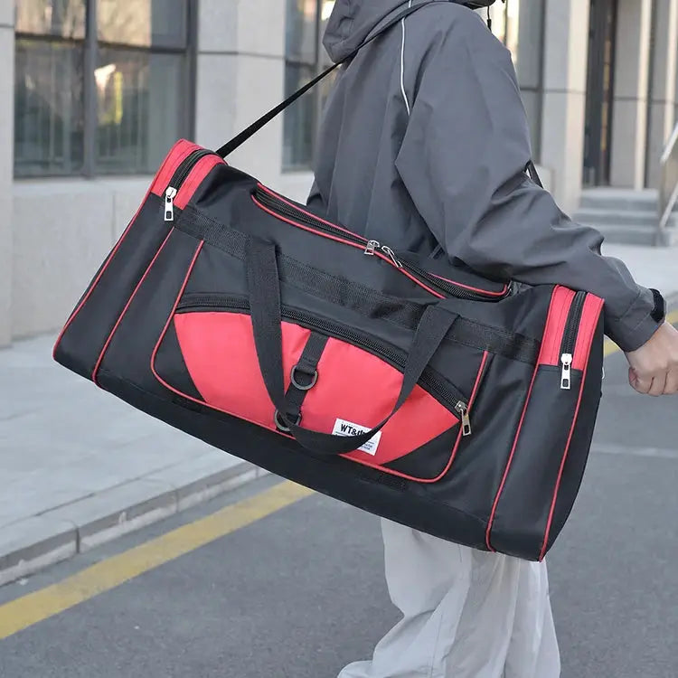 Oversized Simples Market handbag in black with red panels and multiple zip pockets.