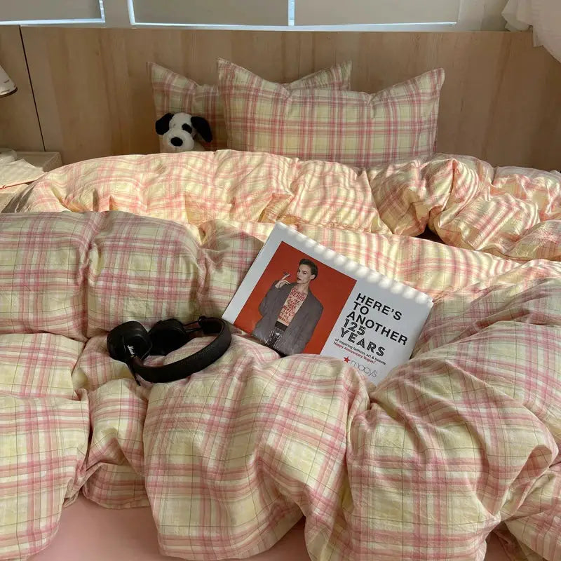 Duvet cover bedding set, 100% cotton, pink and yellow plaid with 2 pillowcases on a bed, magazine and plush dog.