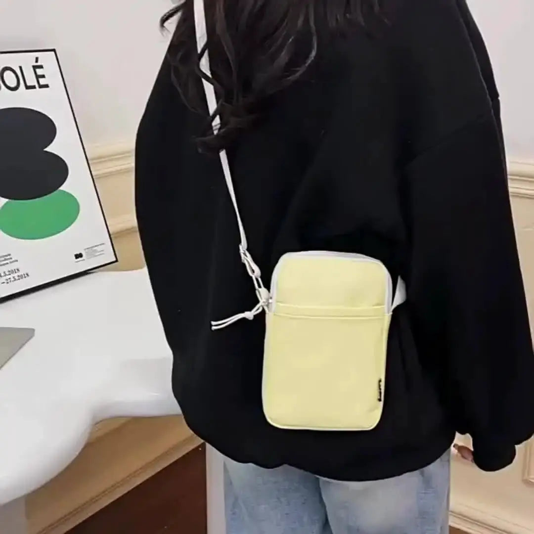 Shoulder bag, pale yellow vertical crossbody with white strap and front pocket