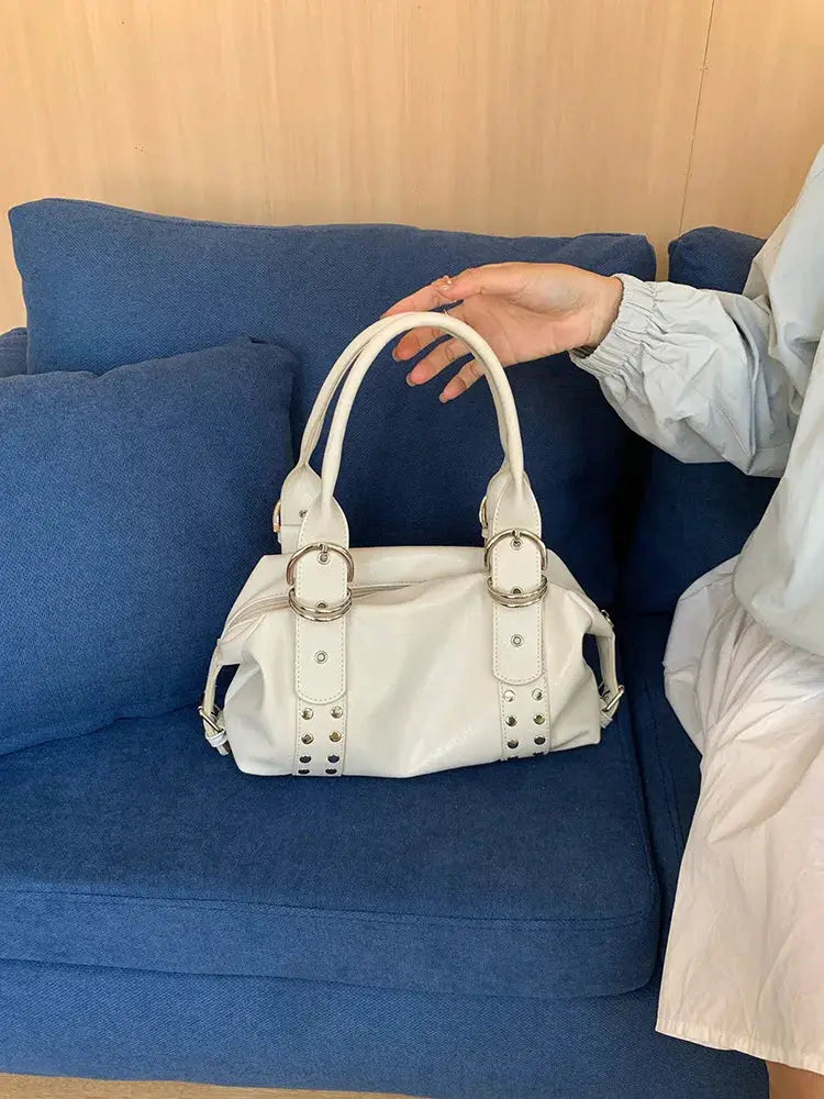 Shoulder bag white PU leather rivet handbag with twin handles and metal rings.