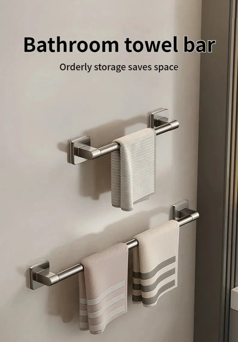 Three brushed stainless steel bathroom towel bars mounted on the wall with towels