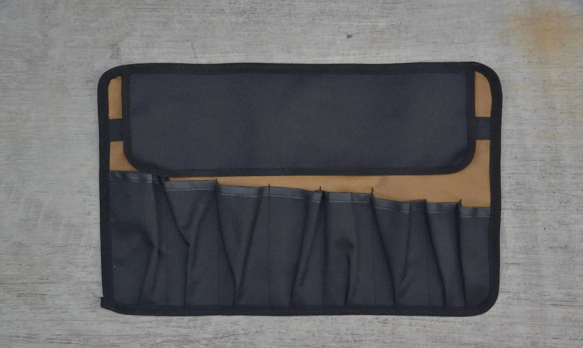 Oxford cloth tool roll pouch with black outer shell and tan interior, featuring multiple elastic tool pockets