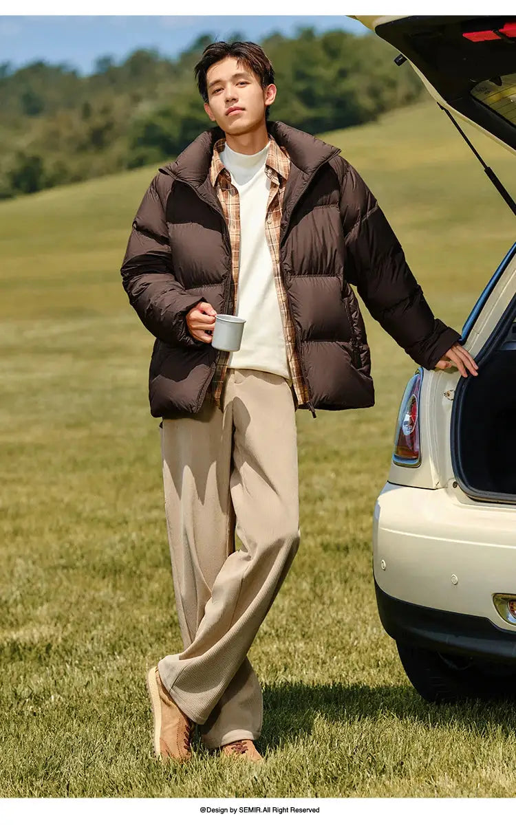 Semir down jacket; brown puffer coat, unisex short-length, man outdoors beside car trunk.
