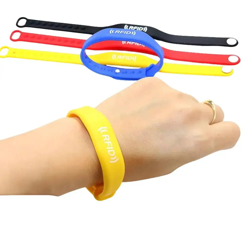 RFID silicone wristband set; 4 color bands in black, red, yellow, blue with RFID logo; worn on wrist.