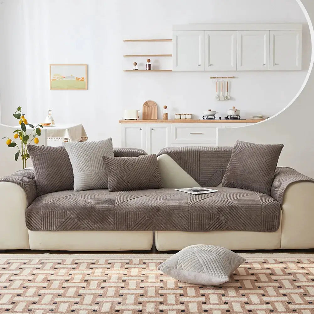 Crystal velvet sofa cover in non-slip brown with matching cushions on a beige sofa in a bright living room