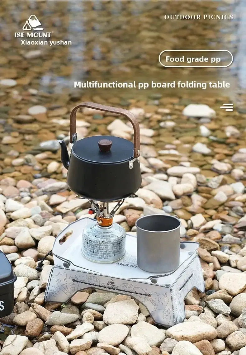 TINSOL ultralight folding mini PP camp table; white tray with grey artwork, kettle on a gas stove and a cup