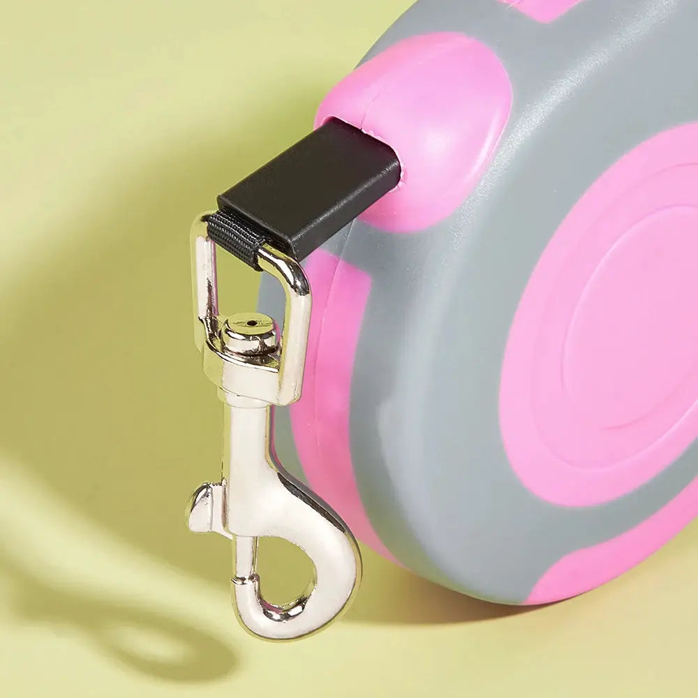 Retractable nylon dog leash with pink and gray housing and metal clip