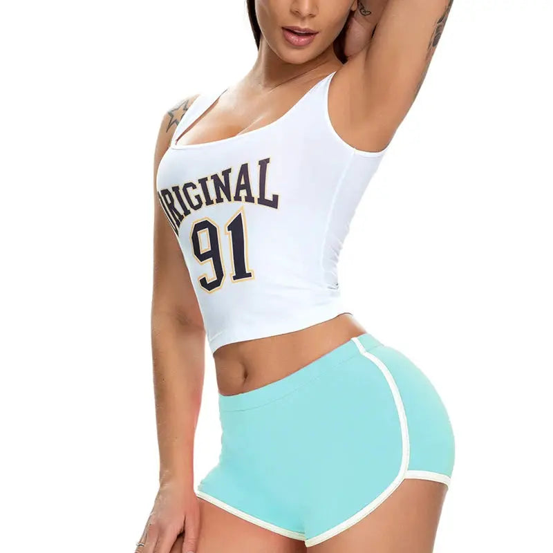 Women’s athletic shorts set: white crop top with ORIGINAL 91 and turquoise shorts with white trim.