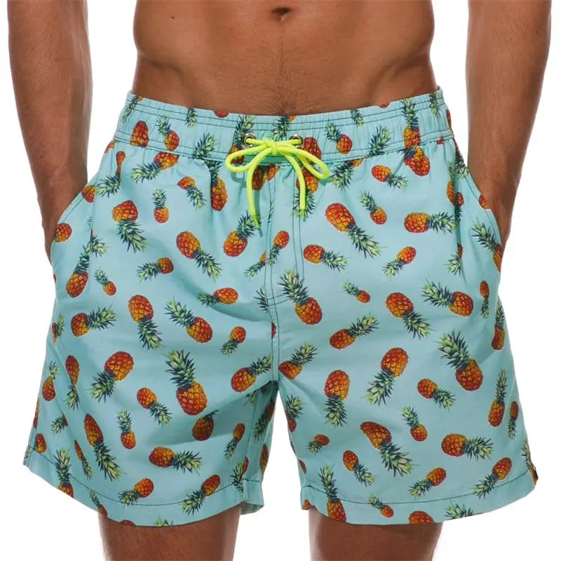 Men's turquoise pineapple-print swim trunks with neon yellow drawstring by Simples Market