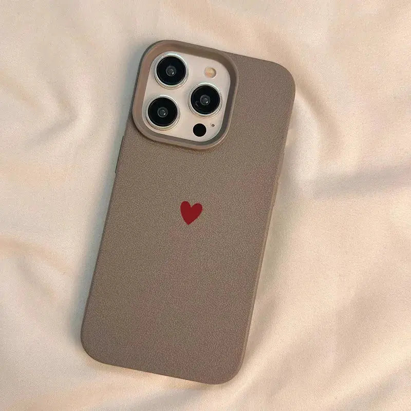 Simple red heart soft TPU phone case in taupe for iPhone, camera cutout visible.