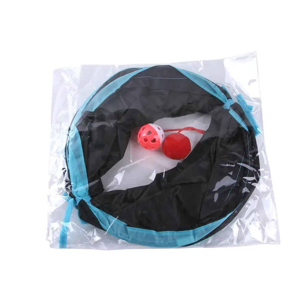 Cat tunnel toy by Simples Market; foldable black tunnel with blue trim, packaged, with two red ball toys inside.
