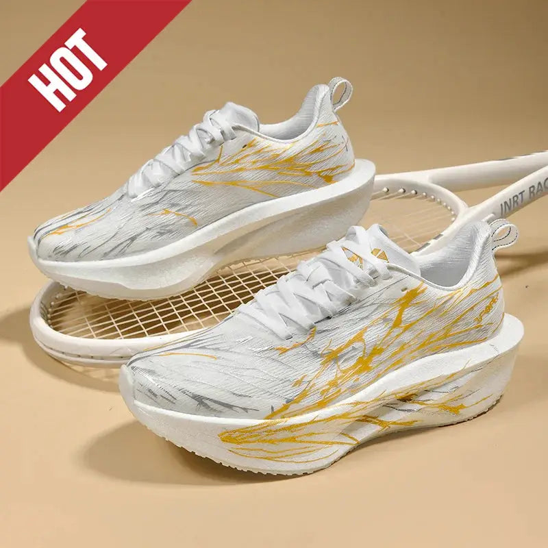 Pair of white running shoes with yellow abstract streaks, breathable lightweight athletic sneakers.