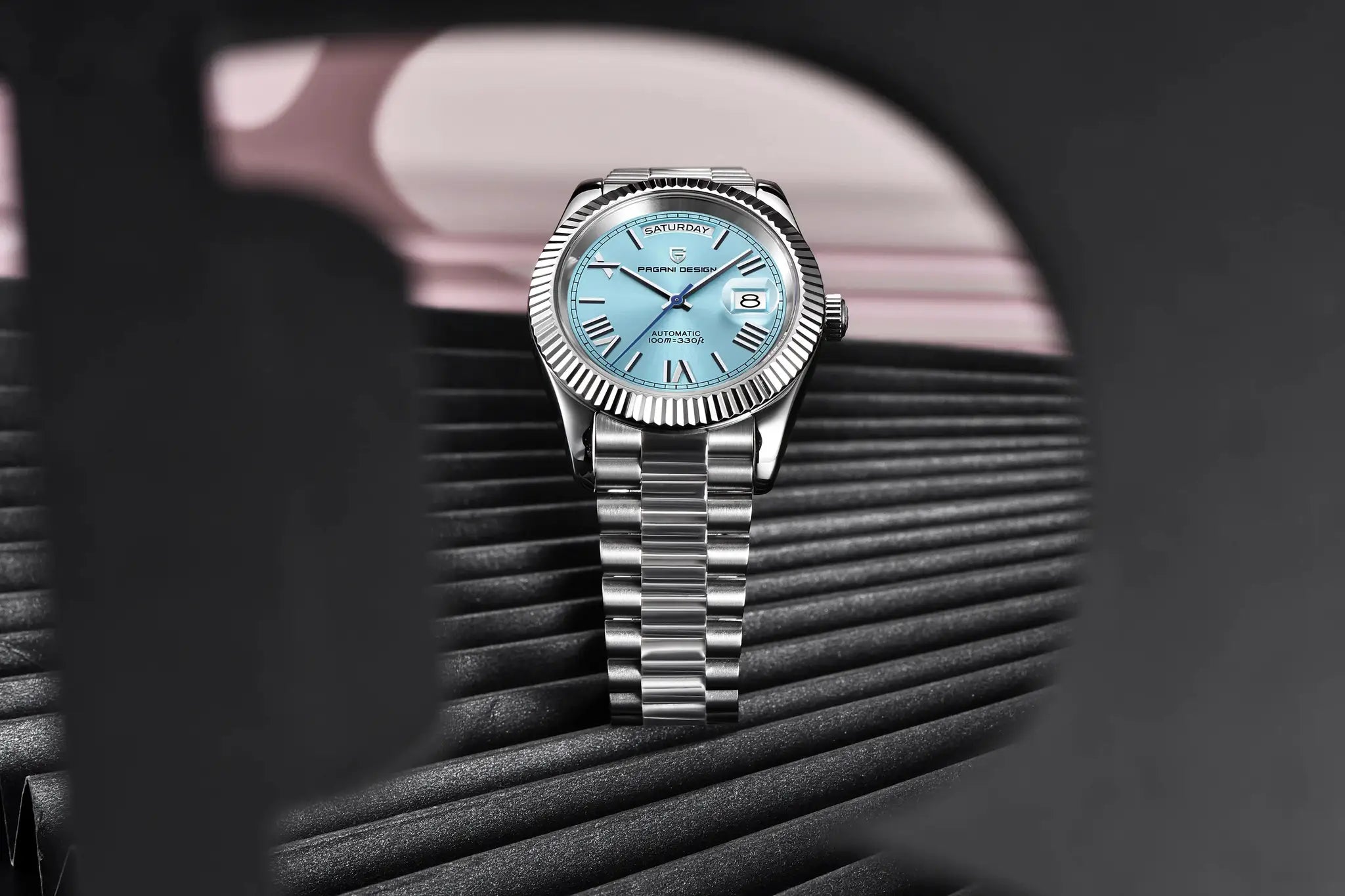 Pagani Design DD40 automatic men's watch with stainless steel bracelet, light blue dial, date window, and fluted bezel.