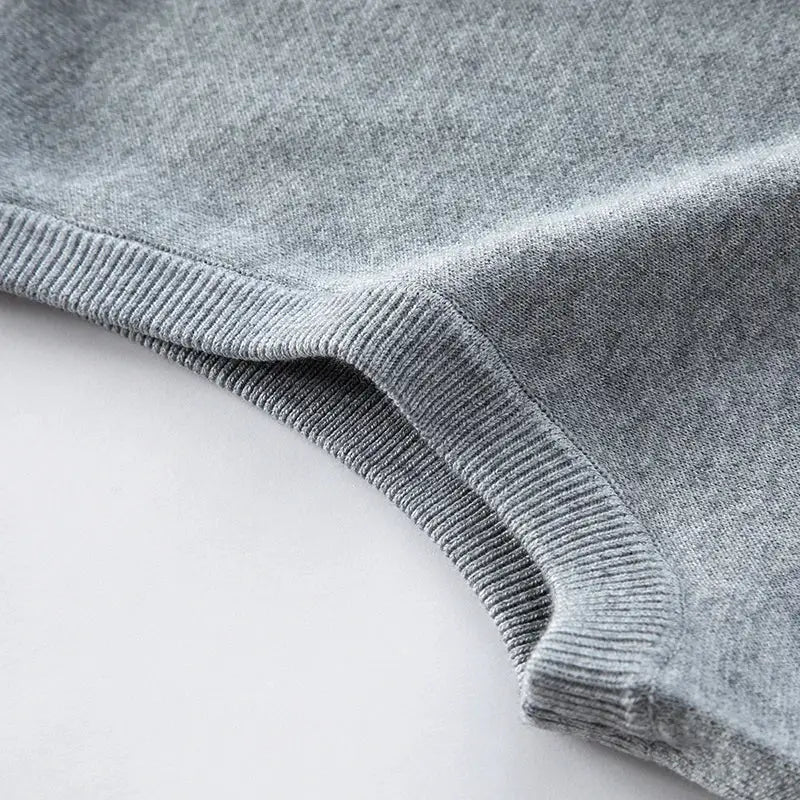 Men's casual sweater vest close-up in grey knit with ribbed trim.